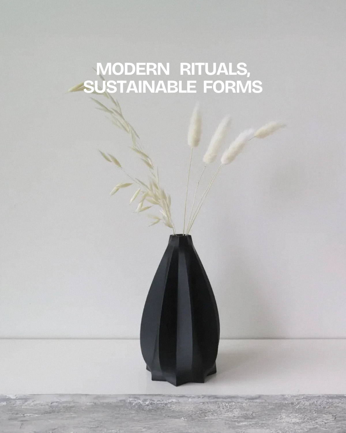 Black sculptural vase by OBJ STUDIO, 3D printed from plant-based PLA and styled with dried stems in a minimal interior.