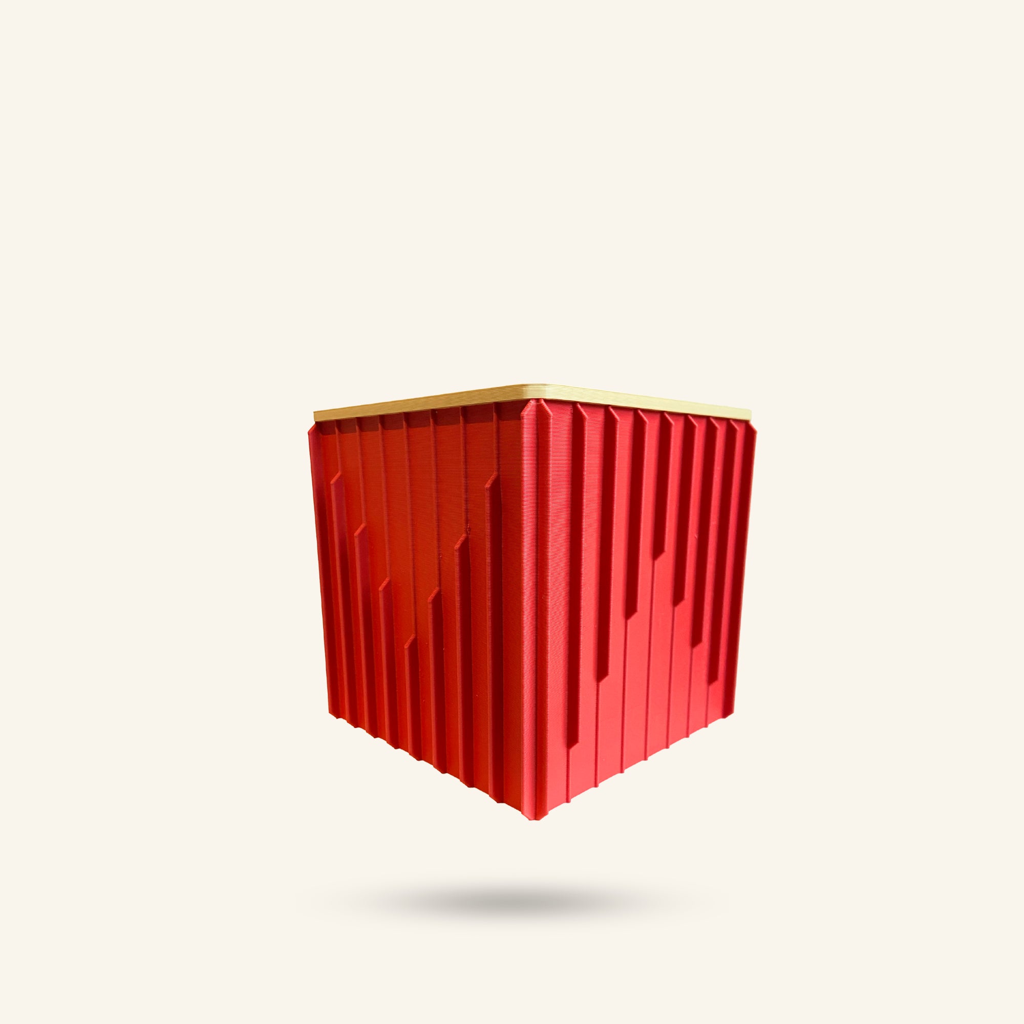 Red geometric container with gold top on a white background